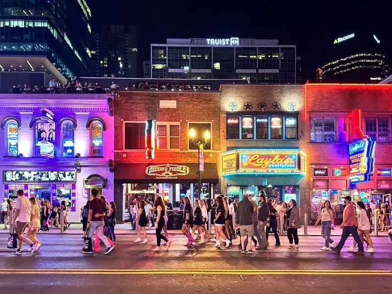 Crowds walking past restaurants and bars on Lower Broadway at night